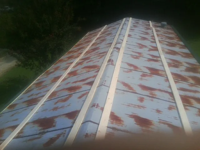 Rusted metal roof panels with new wood purlins before replacement — Storm Damage Roof Repair in Gueydan by Roofing Brothers