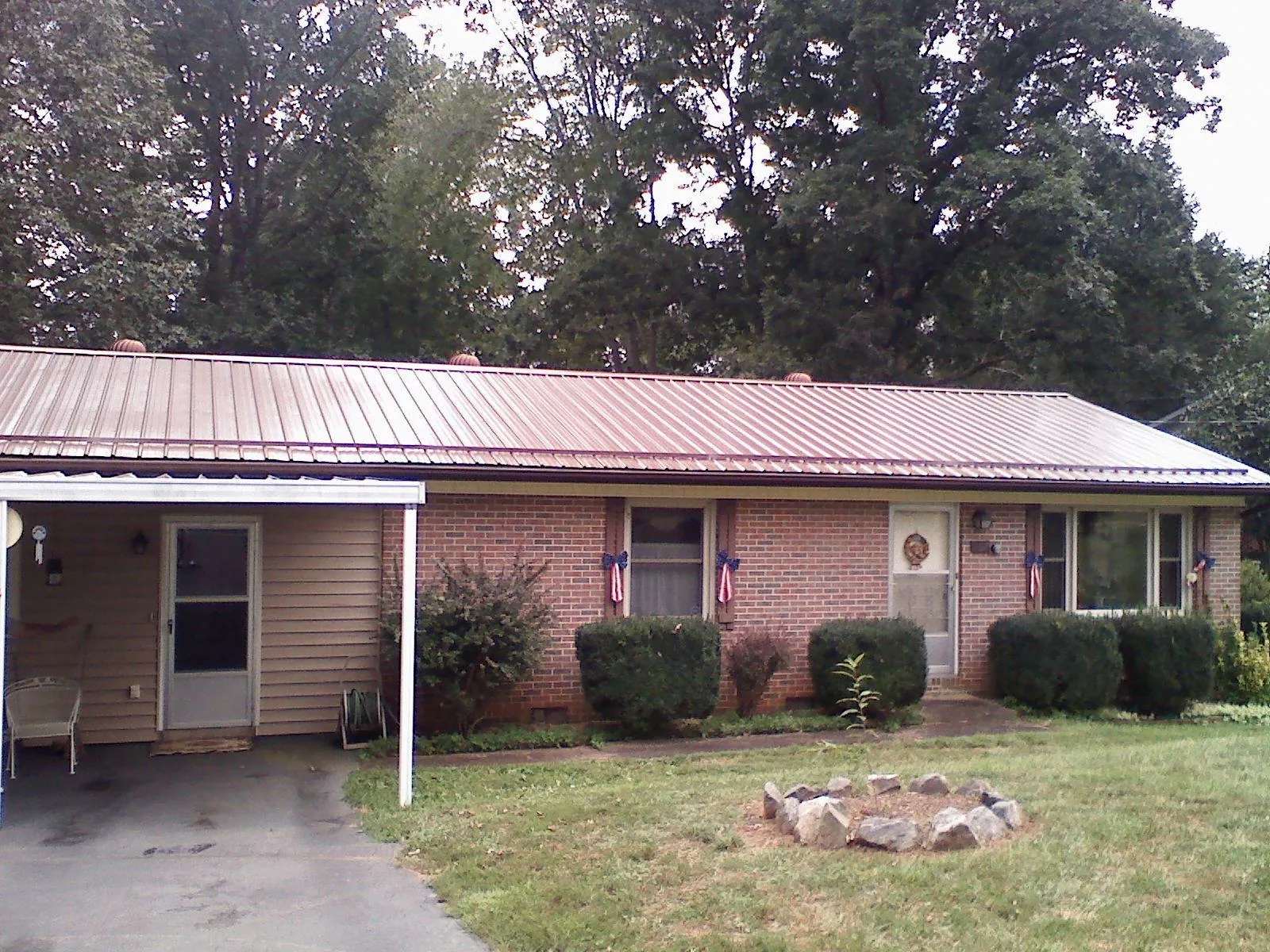 Bronze metal roof and carport on a brick ranch home — Roof Repair work by our crew in Gueydan